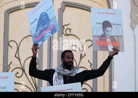 Tunisi, Tunisia, 18 dicembre 2024. Attivisti e manifestanti si riuniscono fuori dal teatro in viale Habib Bourguiba chiedendo diritti per i migranti che intraprendono il pericoloso attraversamento del Mediterraneo per raggiungere l'Italia e l'Europa. I partecipanti hanno denunciato il trattamento dell'Italia nei confronti dei migranti irregolari che raggiungono le sue coste, gli accordi della Tunisia con l'Italia e l'UE per arginare il flusso di arrivi irregolari in Europa e il "nuovo Patto sull'immigrazione e l'asilo” dell'UE. La manifestazione ha coinciso con la giornata internazionale dei migranti Foto Stock