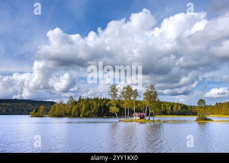 Piccola cabina tradizionale in legno rosso su una piccola isola nel lago in autunno/autunno, Värmland, Svezia centro-occidentale, Scandinavia Foto Stock