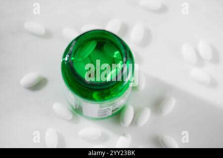 La vitamina D della medicina delle pillole bianche fuoriesce dal flacone su sfondi in marmo bianco primo piano Foto Stock