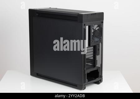 Lato posteriore del telaio vuoto della grande torre per computer, manovrabilità senza sforzo con due ruote incorporate su sfondo bianco. In fondo c'è un posto Foto Stock