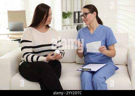 Nutrizionista che dà raccomandazioni alla donna in sovrappeso sul divano in ospedale Foto Stock