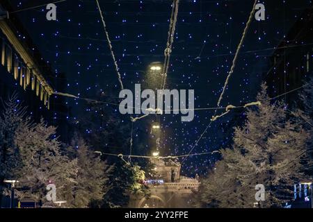 Le iconiche luci Lucy illuminano la Bahnhofstrasse di Zurigo, in Svizzera, proiettando un bagliore sulla strada innevata durante la prima nevicata della stagione Foto Stock