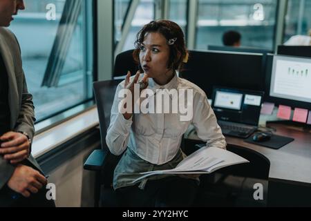 Diversi colleghi aziendali si riuniscono in un ufficio moderno per raccogliere idee nuove, promuovere il lavoro di squadra e l'innovazione. Foto Stock