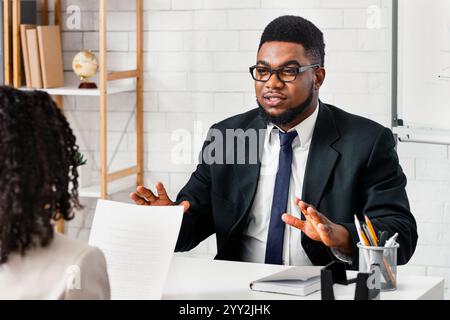 Candidato millenario che risponde alle domande del responsabile delle risorse umane durante il colloquio di lavoro in ufficio Foto Stock