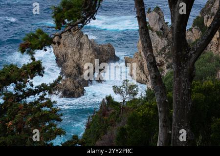 Una piccola isola rocciosa solitaria in mare aperto. Tempesta in mare, onde infurianti che si infrangono contro la piccola isola ed esplodono con spruzzi bianchi. Rock in A. Foto Stock