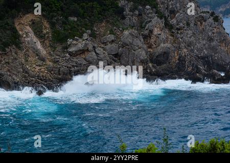 Una piccola isola rocciosa solitaria in mare aperto. Tempesta in mare, onde infurianti che si infrangono contro la piccola isola ed esplodono con spruzzi bianchi. Rock in A. Foto Stock