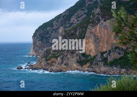 Una piccola isola rocciosa solitaria in mare aperto. Tempesta in mare, onde infurianti che si infrangono contro la piccola isola ed esplodono con spruzzi bianchi. Rock in A. Foto Stock