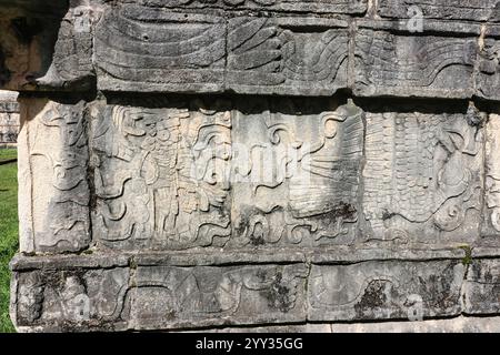 Primo piano di un Guerriero con una testa nemica decapitata su una delle pareti di Platform of Eagles and Jaguar, Chichen Itza, rovine Maya, Messico Foto Stock