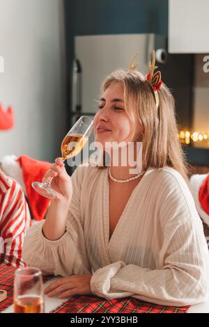 Ritratto di donna bionda con corna di cervo che festeggia il Natale con gli amici Foto Stock
