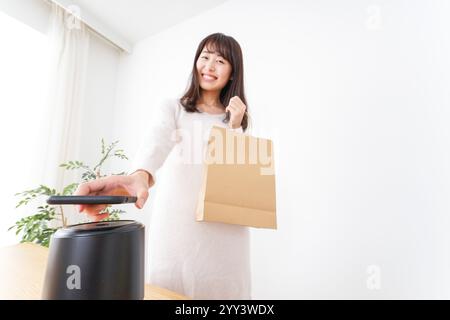 Giovane donna che fa pagamenti elettronici Foto Stock