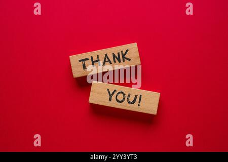 Grazie è scritto su blocchi di legno su sfondo rosso Foto Stock