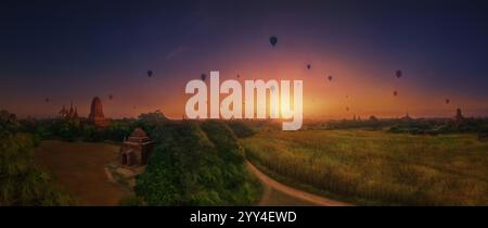 L'accattivante alba tramonta il cielo mentre le mongolfiere si spostano sopra antichi templi, il tranquillo paesaggio fonde la storia con la bellezza della natura Foto Stock