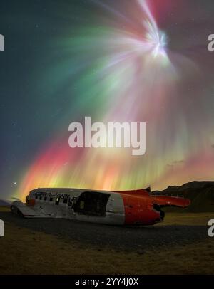 Un'immagine accattivante dell'aurora boreale che balla sul relitto dell'aereo Solheimasandur vicino a Hella, in Islanda, che mostra l'eterea bellezza della regione Foto Stock