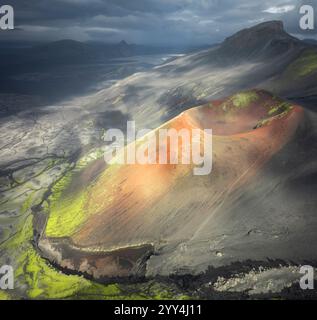 Una vista aerea di un colorato cratere vulcanico in Islanda, che mostra muschio vibrante e terreno accidentato sotto cieli spettacolari, Uno splendido esempio di Islanda Foto Stock
