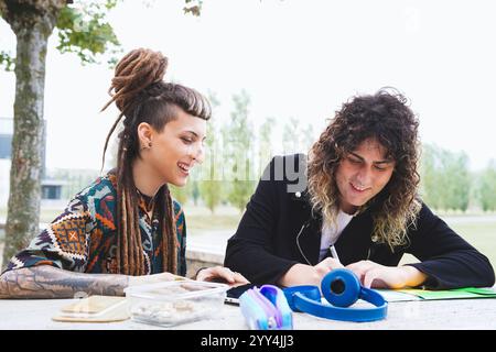 Una coppia transgender ama trascorrere una giornata all'aperto, con una persona che presenta dreadlock e una frangia, che si identifica come agender, e l'altra che ha un riccio sportivo Foto Stock