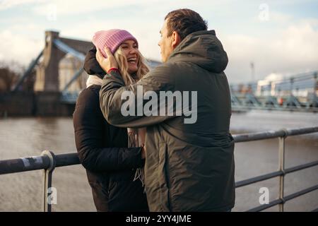 Una giovane coppia sposata, assaporate il loro tempo insieme camminando lungo un fiume a Breslavia, incarnando sentimenti di amore e fedeltà. Catturati al fresco Foto Stock