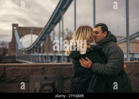 Una giovane coppia sposata, un uomo e una donna, condividono un tenero abbraccio nella città di Breslavia, in Polonia. La coppia si guarda, profondamente engrosse Foto Stock