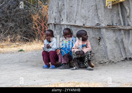 MTO wa MBU, Tanzania - 4 agosto 2024. Primo piano di un gruppo di bambini Masai, vicino alla città di MTO wa MBU nel nord della Tanzania, seduti fuori dalla loro capanna. I Masai sono conosciuti per il loro stile di vita tradizionale come contadini. Foto Stock