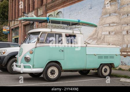 Port Townsend, Washington, Stati Uniti - 25 marzo 2022: Camper VW kombi vintage blu-verde anni '1960 o microbus modificato come pick-up con tavole da surf sul tetto parcheggiate Foto Stock