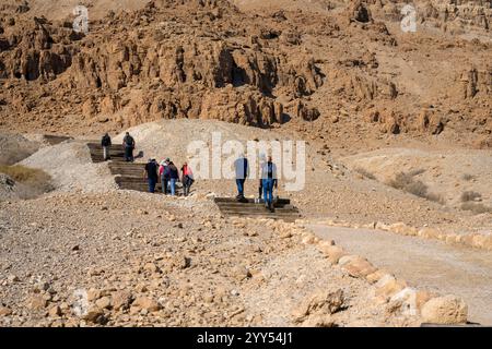 Escursionisti che camminano fino alle grotte nella scogliera di Marl presso il sito archeologico di Qumran sulla riva del Mar morto, in Cisgiordania, Israele, il sito di Qumran è Be Foto Stock
