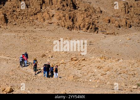 Escursionisti che camminano fino alle grotte nella scogliera di Marl presso il sito archeologico di Qumran sulla riva del Mar morto, in Cisgiordania, Israele, il sito di Qumran è Be Foto Stock