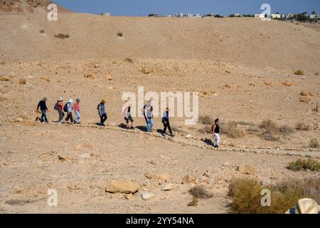 Escursionisti che camminano fino alle grotte nella scogliera di Marl presso il sito archeologico di Qumran sulla riva del Mar morto, in Cisgiordania, Israele, il sito di Qumran è Be Foto Stock