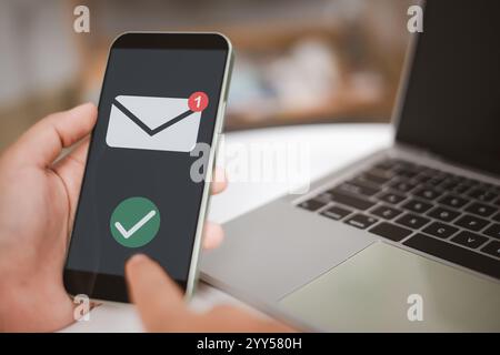 Una persona ha un telefono cellulare e controlla l'e-mail, è probabile che stia controllando l'e-mail, nuovo concetto di notifica e-mail per comunicazioni e-mail aziendali Foto Stock
