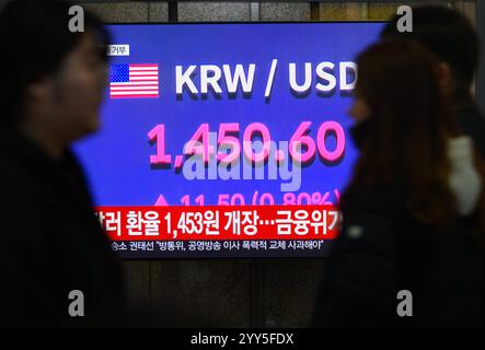 Seoul, Corea del Sud. 19 dicembre 2024. Una trasmissione televisiva Yonhapnews della durata di 24 ore alla stazione ferroviaria di Yongsan a Seul che mostra una trasmissione di notizie con il tasso di cambio tra il dollaro statunitense e il won sudcoreano. La valuta sudcoreana si aprì nettamente più in basso rispetto al dollaro statunitense il 19 dicembre, violando il 1.450 per la prima volta dalla crisi finanziaria globale del 2009. Il won coreano aprì a 1.453 won per dollaro, contro 17,5 won rispetto alla sessione precedente. Segna il livello più basso dal 1.488 vinto il 16 marzo 2009. (Immagine di credito: © Kim Jae-Hwan/SOPA Images via ZUMA Press Wire) EDITORIALE USA Foto Stock