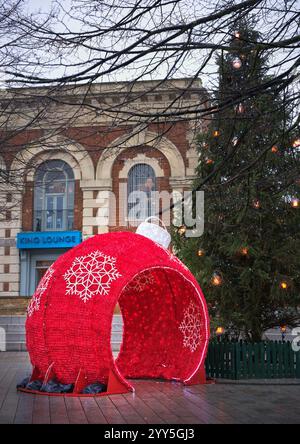 La grotta rossa di Babbo Natale nel mercato di Kettering, in Inghilterra, in una giornata invernale umida, 2024. Foto Stock