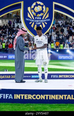 Doha, Qatar. 18 dicembre 2024. Vinicius Junior del Real Madrid posa per una foto insieme a Khalid al Zamil, Vicepresidente degli affari pubblici, Aramco, dopo essere stato presentato con il giocatore della Coppa Intercontinentale FIFA del trofeo del torneo dopo la finale della Coppa Intercontinentale FIFA tra il Real Madrid spagnolo e il Pachuca messicano, allo stadio Lusail, a Doha, Qatar, il 18 dicembre, 2024. foto: Ahmed Alsaidi/DiaEsportivo credito: Action Plus Sports/Alamy Live News Foto Stock