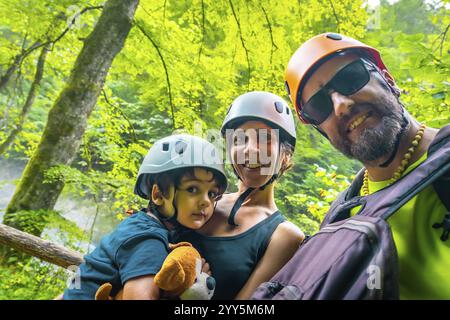 Famiglia felice che scatta selfie mentre cammina e indossa il casco nella splendida gola di vintgar vicino a Bled, slovenia Foto Stock