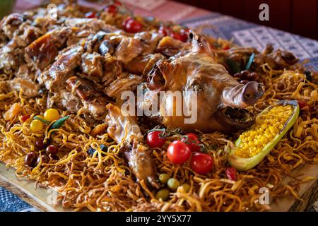 Un maialino da latte arrosto su spiedino, servito su un vassoio, decorato con vegetazione e verdure. Griglia tradizionale della Serbia, campagna. Foto Stock