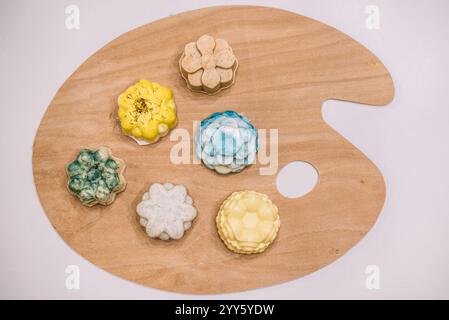 Vista dall'alto dei bar con splendidi, profumati e colorati saponi fatti in casa su un paletto di pittura. Processo a freddo naturale fatto a mano, produzione di sapone naturale. Foto Stock
