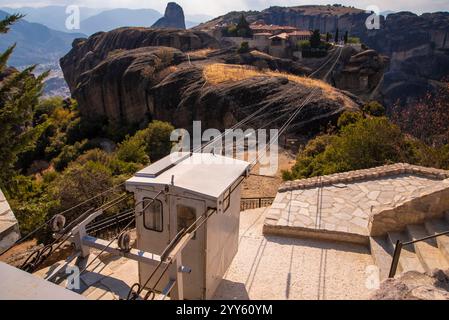 Funivia (funivia di trasporto) che collega le formazioni rocciose di Meteora e il monastero ortodosso di Áyios Ayía Triáda (Santa Trinità) appeso su una scogliera Foto Stock
