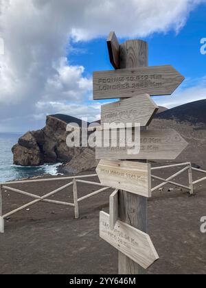 Capelo, Portogallo. 25 settembre 2024. L'area delle escursioni al vulcano Vulcao dos Capelinhos con indicazioni per Berlino e Parigi, tra gli altri. Un'eruzione vulcanica nel settembre 1957 creò una nuova isola vulcanica, che si fuse con l'isola principale di Faial. La penisola fu battezzata Ponta dos Capelinhos. Crediti: Jens Kalaene/dpa/Alamy Live News Foto Stock