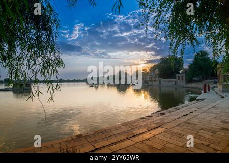 Sole si trova dietro l'ingresso principale del lago Gadisar, Jaisalmer, Rajasthan, India. Lago artificiale storico, una volta sola risorsa idrica per la città di Jaisalmer. Foto Stock