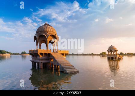 Splendida Chhatris, padiglioni a forma di cupola sul lago Gadisar o sul lago Gadaria, un lago artificiale un tempo solo fonte d'acqua della città di Jaisalmer. Cielo blu. Foto Stock