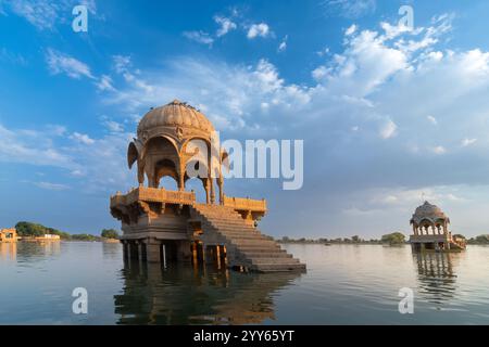 Splendida Chhatris, padiglioni a forma di cupola sul lago Gadisar o sul lago Gadaria, un lago artificiale un tempo solo fonte d'acqua della città di Jaisalmer. Cielo blu. Foto Stock