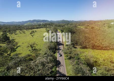 Piccoli autocarri su strada asfaltata nel paesaggio aereo dell'agricoltura verde Foto Stock