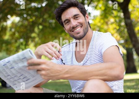 uomo d'affari che legge il giornale nel parco Foto Stock