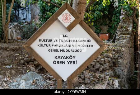 Kayakoy, Mugla, Turchia - 12 ottobre 2024: Indicazione per la città fantasma di Kayakoy. Villaggio greco abbandonato con case in pietra sbriciolate, rovine storiche e un haunti Foto Stock