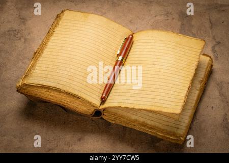 diario vuoto rilegato in pelle retrò con bordo decorato pagine di carta fatte a mano con un'elegante penna su carta artistica fatta a mano, concetto di journaling Foto Stock