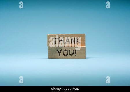 Grazie è scritto su blocchi di legno su sfondo blu Foto Stock