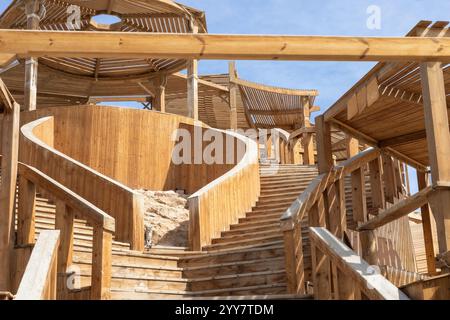 Accattivante immagine di una scala rustica in legno che sale a un padiglione, sotto un cielo azzurro Foto Stock