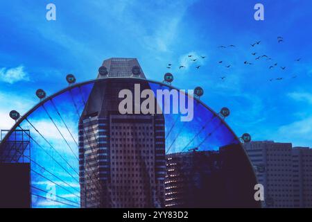 Una splendida vista di una ruota panoramica urbana adagiata su un cielo spettacolare e colorato Foto Stock