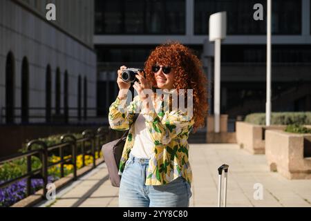 Turisti che scattano foto mentre camminano nel centro della città Foto Stock