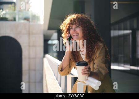 Allegra donna d'affari parla al telefono all'aperto durante le pause Foto Stock