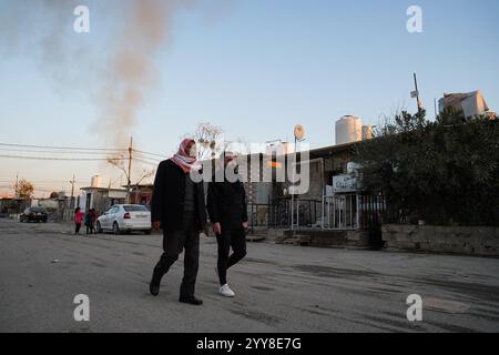 La gente cammina per la strada del campo di Domiz per i rifugiati curdi siriani a circa 18 km a sud-ovest della città di Duhok nella regione del Kurdistan. La provincia di Duhok ospita 92.000 rifugiati siriani su 275.000 rifugiati nella regione del Kurdistan in Iraq che sono migrati dallo scoppio della rivoluzione siriana nel 2011. La maggior parte di loro si rifiuta di tornare nel loro paese nonostante la caduta del regime di Bashar al-Assad per paura dello scoppio di conflitti armati tra le forze democratiche siriane (SDF) e l'esercito nazionale siriano sostenuto dai turchi o con Hayat Tahrir al-Sham e altre forze di opposizione che hanno preso parte Foto Stock