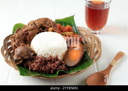 Nasi Gudeg, cibo tipico di Yogyakarta, Indonesia. Riso con stufato di Jackfruit cotto con latte di cocco. Servita con tè caldo Foto Stock