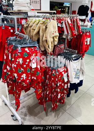 Kiev, Ucraina - 18 dicembre 2024: Un vivace negozio di abbigliamento a tema natalizio, tra cui pigiama e costumi, pronto per le vacanze Foto Stock